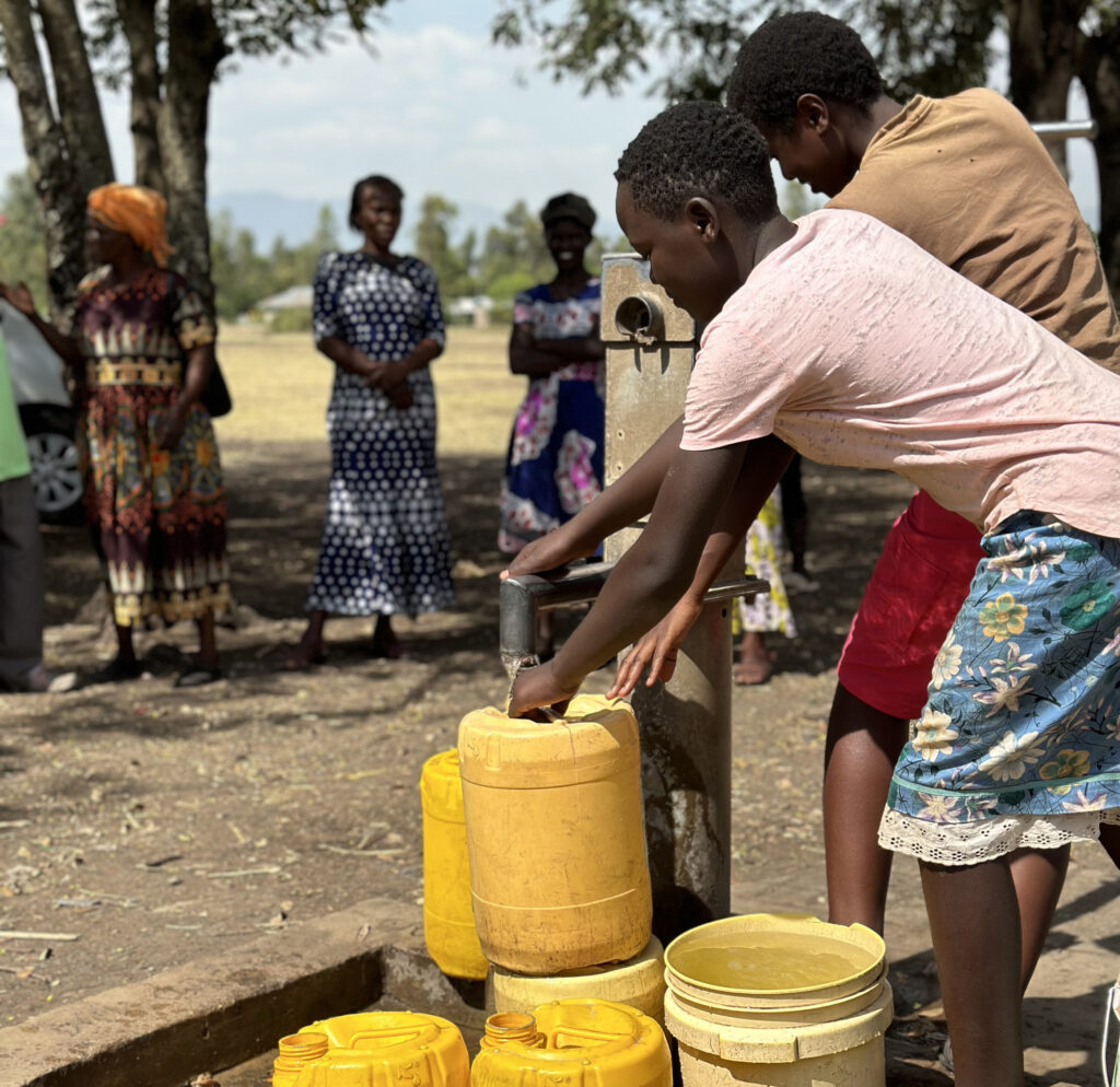 Community members drawing clean water from a WellBoring well